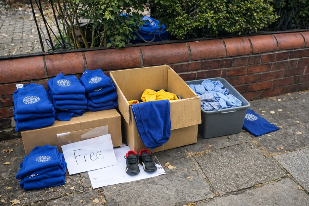 Free school clothes neatly sorted and on display in boxes outside someone's house. 
